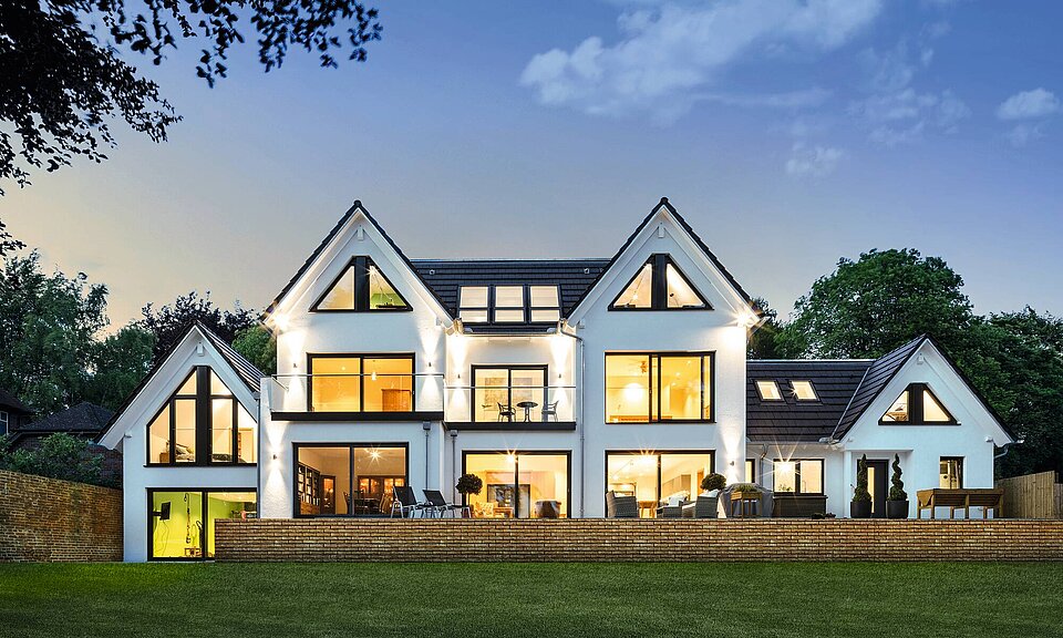 House with large window front in evening mood House with large window front in evening moodTwo gables